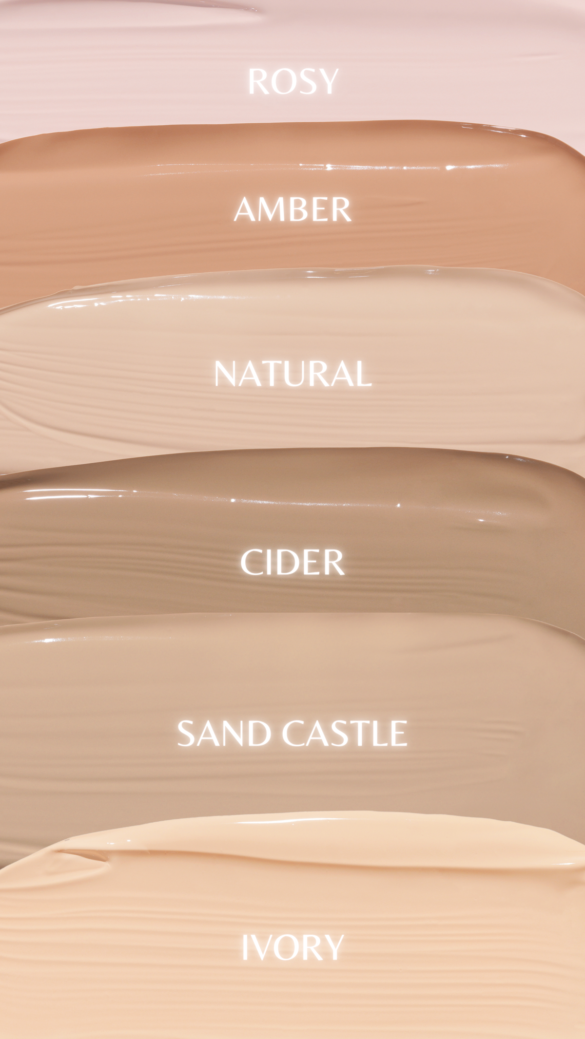 Six makeup swatches in warm light beige and peach tones labeled ROSY, AMBER, NATURAL, CIDER, SAND CASTLE, and IVORY on a pale pink background.